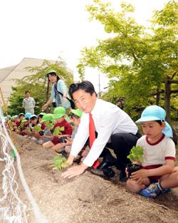 植え方の手本を示す市長