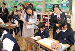子どもたちの学習を覗き込む中国の教職員