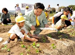 園児と苗を植える市長