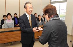学童保育の代表者1人ずつに寄付金を手渡す
