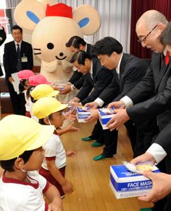 子どもたちにマスクを手渡す