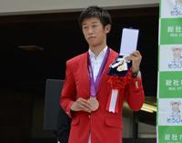 市民栄誉賞の記章を手にする清水選手