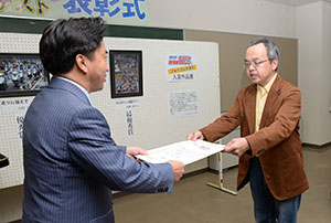 表彰状を渡す