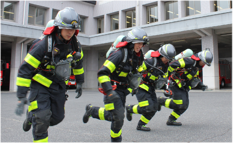 防火装備を装着し訓練をする4人の消防士画像