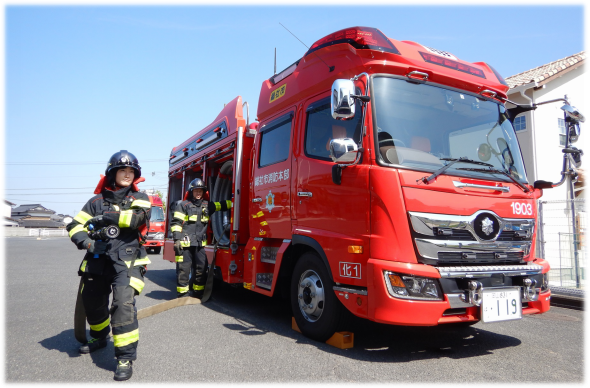 化学消防ポンプ自動車からホースを伸ばして放水姿勢をする画像