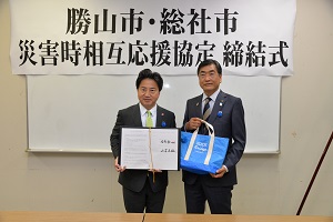 協定書を手にする両市長