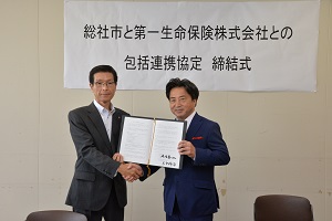 協定書を前に握手