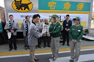 返礼米を配送業者に手渡す